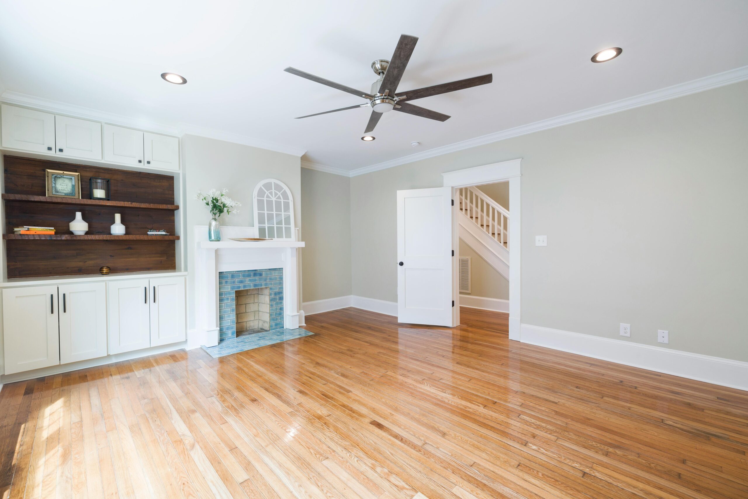Spacious and bright living room featuring hardwood floors and a classic fireplace.
